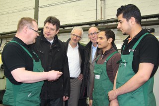 Hochmotiviert und talentiert: Schleswig-Holsteins Wirtschaftsminister Reinhard Meyer (2. von links) lässt sich von Ausbildungsmeister Michael Wächtler (links) den Fortschritt in der Ausbildung von Abdo Dohaim (2. von rechts) und Ehab Ali Musead (rechts) erläutern. Interessierte Zuhörer: Betriebsinhaber Heribert Höhrt (3. von rechts) und Ralf Stamer, Vizepräsident der Handwerkskammer Lübeck (3. von links).